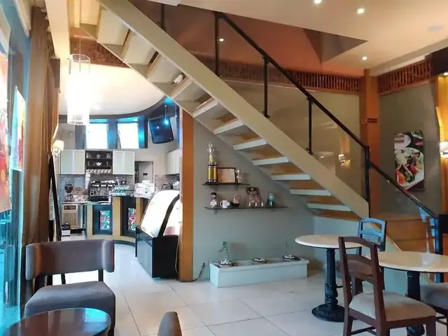 Ilustrasi interior kafe: meja, kursi, dan area kasir — bukan foto lokasi OGI